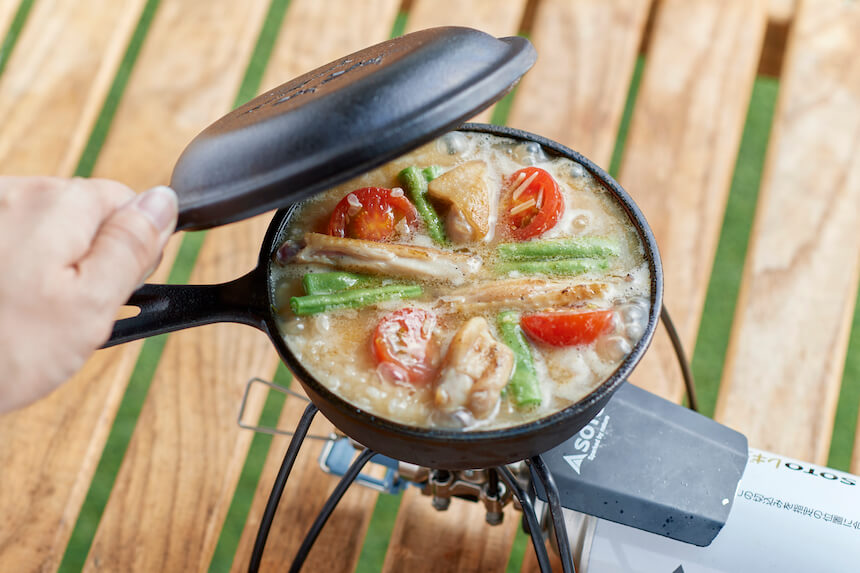 鶏肉とインゲンとトマトをのせ、フタをするようす