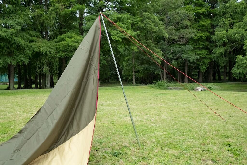 ポールを幕の外側に角度をつけて立ちあげているようす