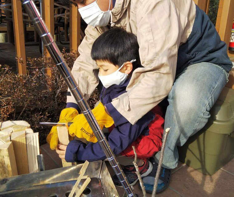 男の子に薪割りを教える父親