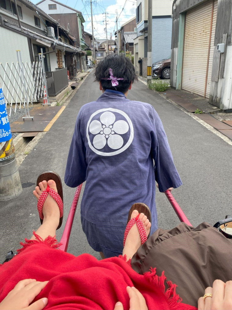 忍者車から見る車夫さんの背中と街並みの写真