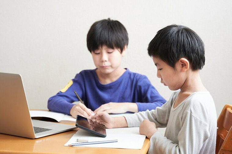 テーブルで勉強する兄弟