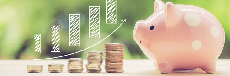 積み上げられた硬貨と豚の貯金箱
