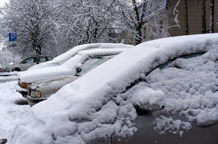 大雪を被ったクルマが並ぶ駐車場