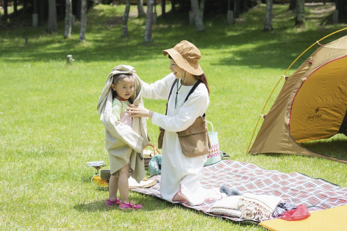 水遊びをした子どもをタオルで拭いているようす