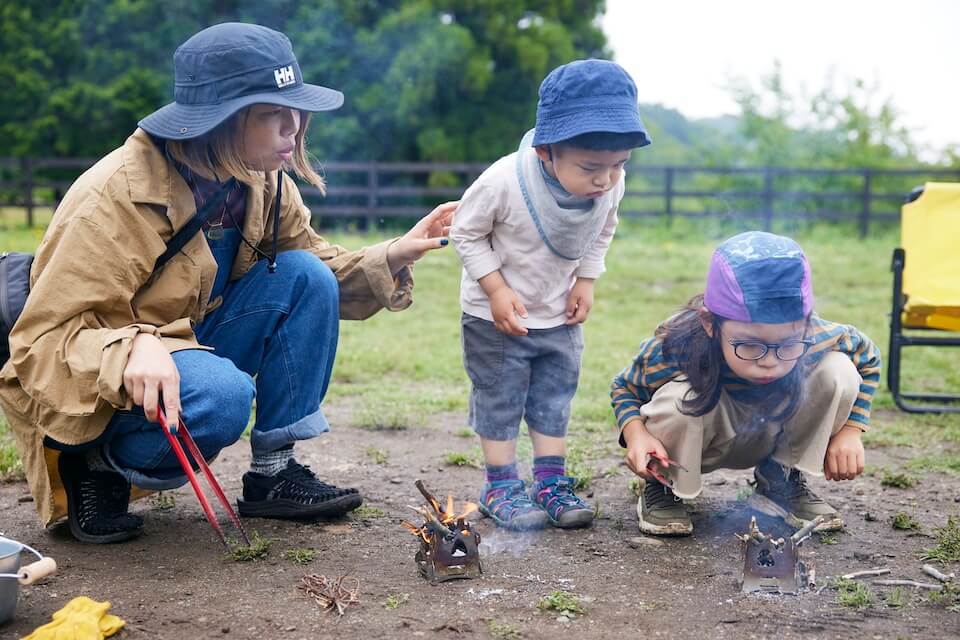 息を吹いて火を大きくしている子ども