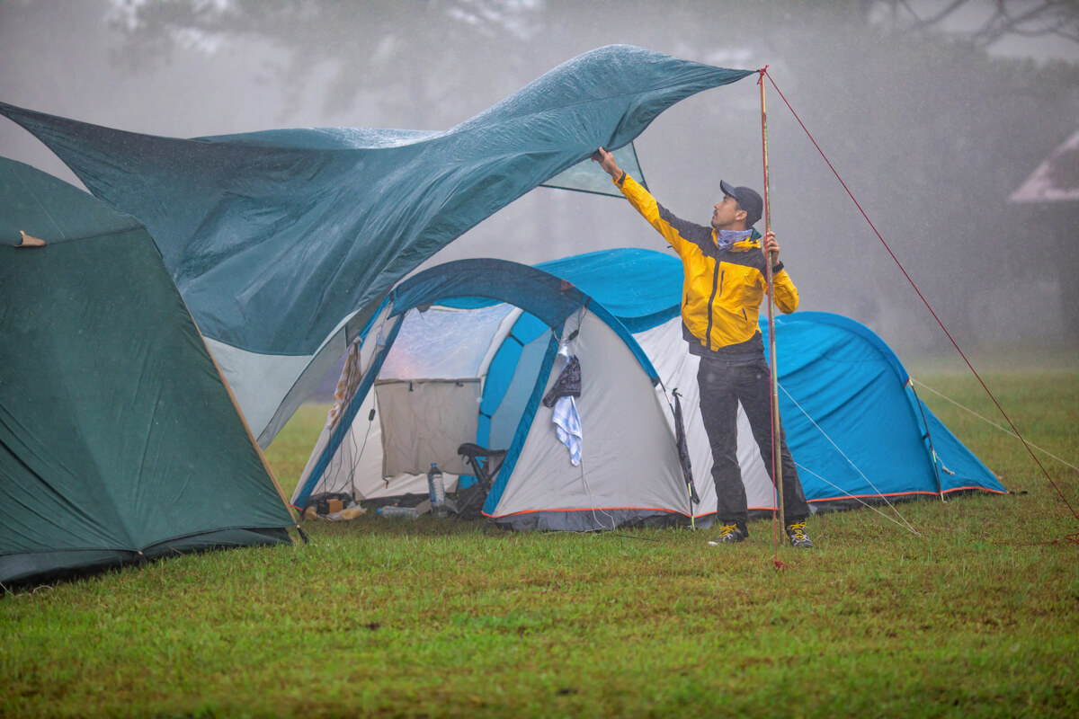 キャンプ場で雨と風にタープが煽られてるようす