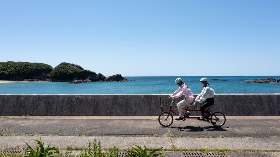 2人用自転車でサイクリング中の二人