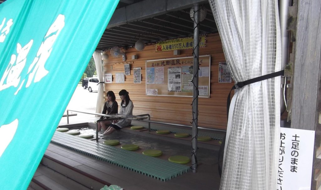 2人の女性が足湯につかっている。