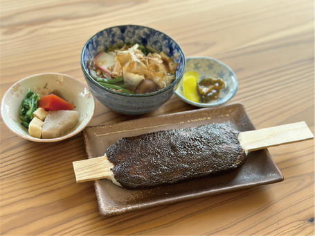 串に刺さった五平餅と、うどん、小鉢がセットになった食事。