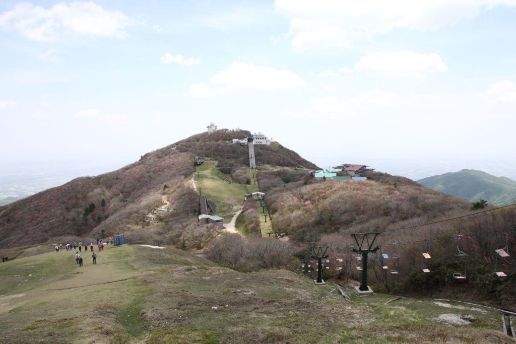 桜が咲く山に、リフトや展望台などの施設がある。