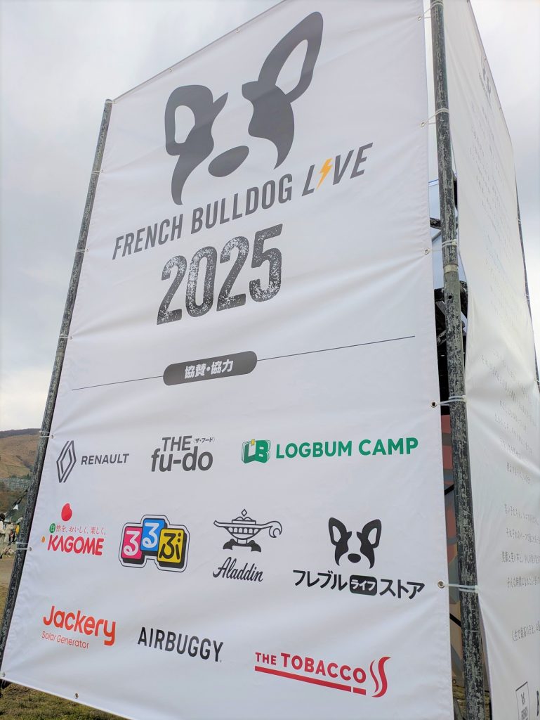 「FRENCH BULLDOG LIVE 2025」と書かれた白いのぼり旗。ロゴと協賛企業の名前が記載されている。