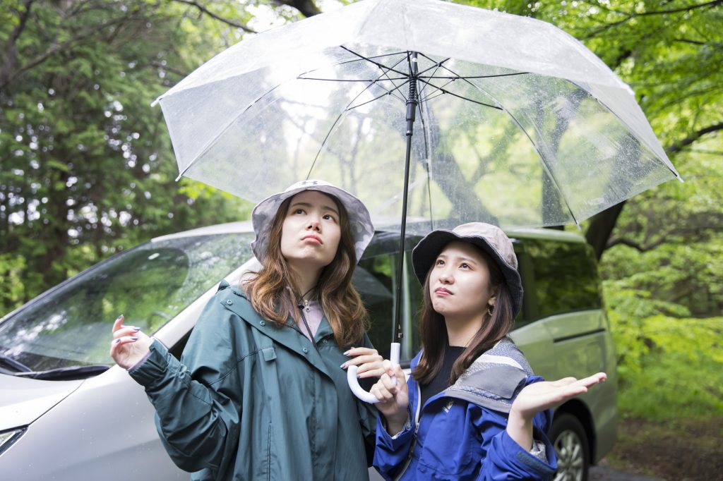 キャンプ場に到着して雨が降っていてがっかりする女性