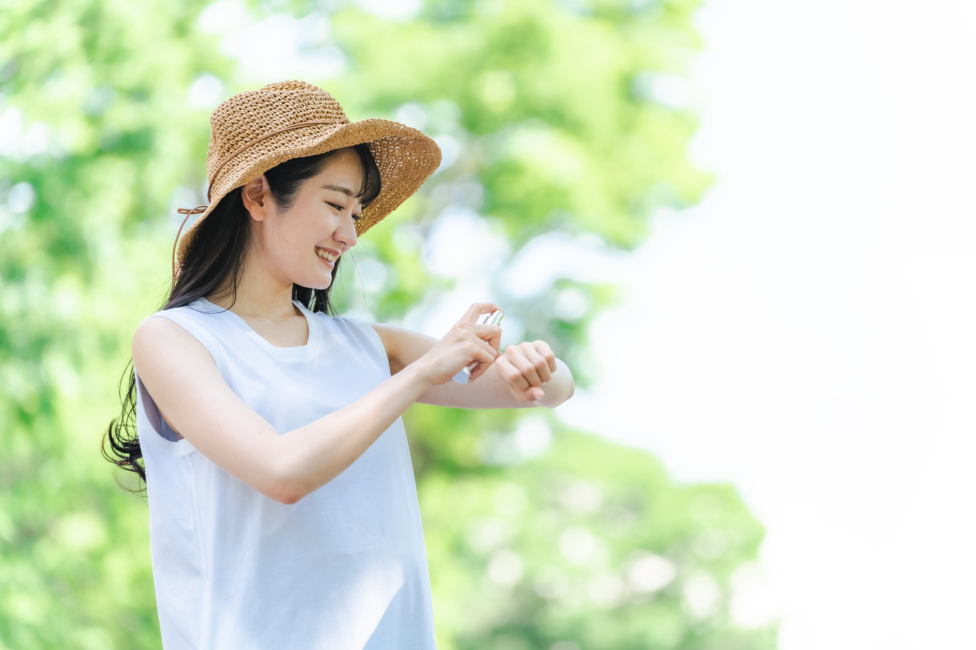 日焼け止め・虫除けスプレーする女性