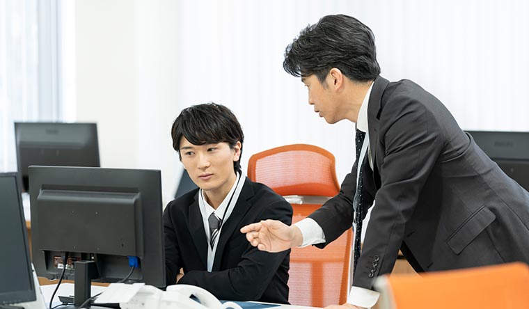 先輩社員にレクチャーしてもらう会社員のイメージ画像