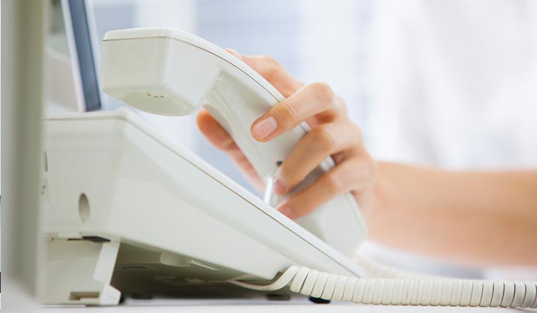 電話の受話器を手に取る様子