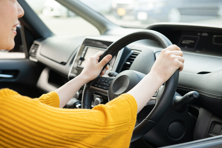 車のハンドルを握る女性